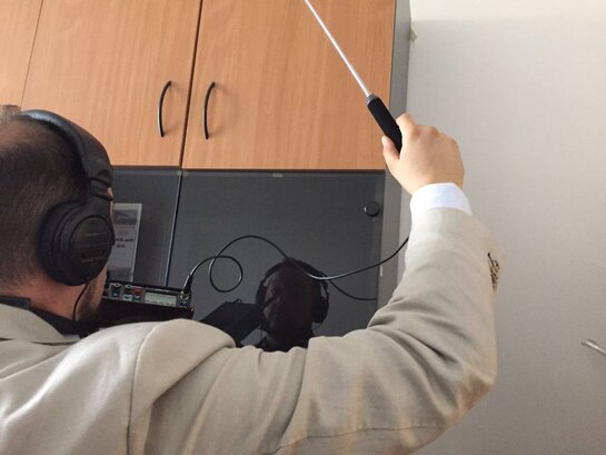 Verifica di microspie in un soggiorno domestico con rilevatore elettronico
